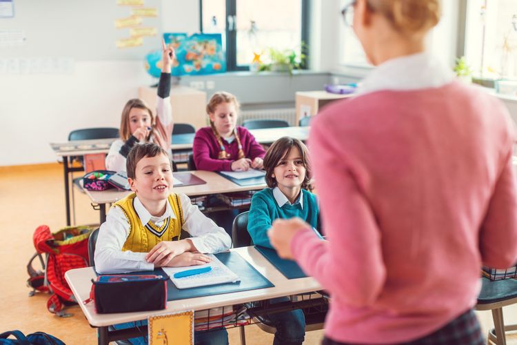 Lehrerin spricht zu Schüler:innen im Klassenraum