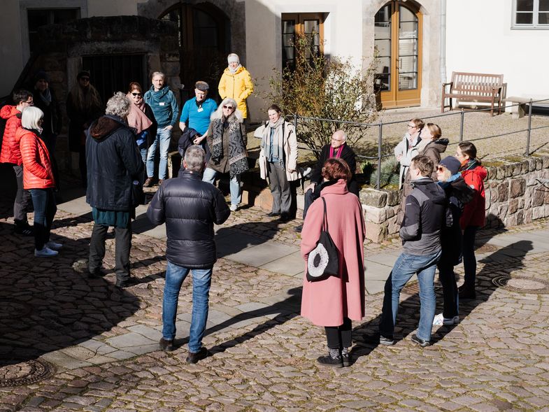 Menschen stehen im Kreis im Innenhof des Klosterhofs